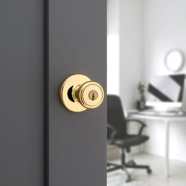 Perilla de puerta de entrada con llave exterior de latón pulido Tylo de la serie Kwikset con tecnología antimicrobiana